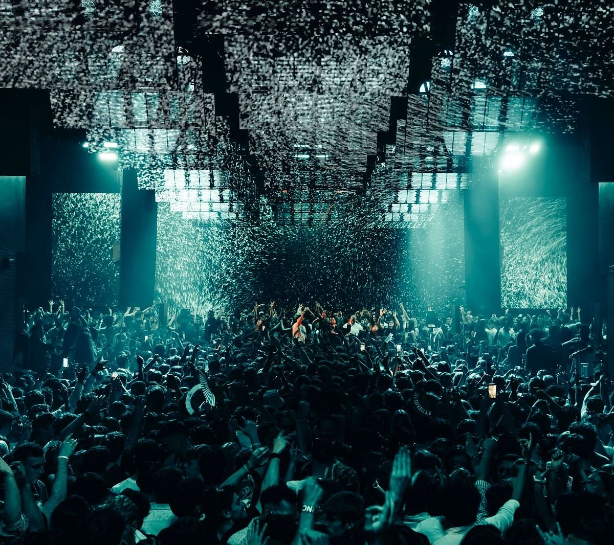 Hï Ibiza crowd beneath immersive teal lighting and mirrored ceiling panels