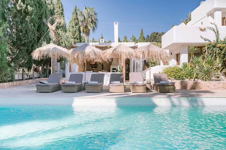 Poolside sun loungers under thatched parasols
