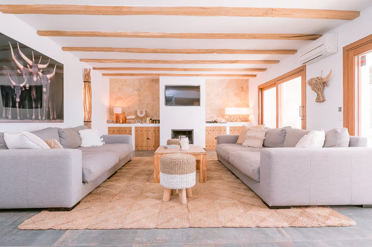 Bright lounge with grey sofas and natural wood ceiling beams