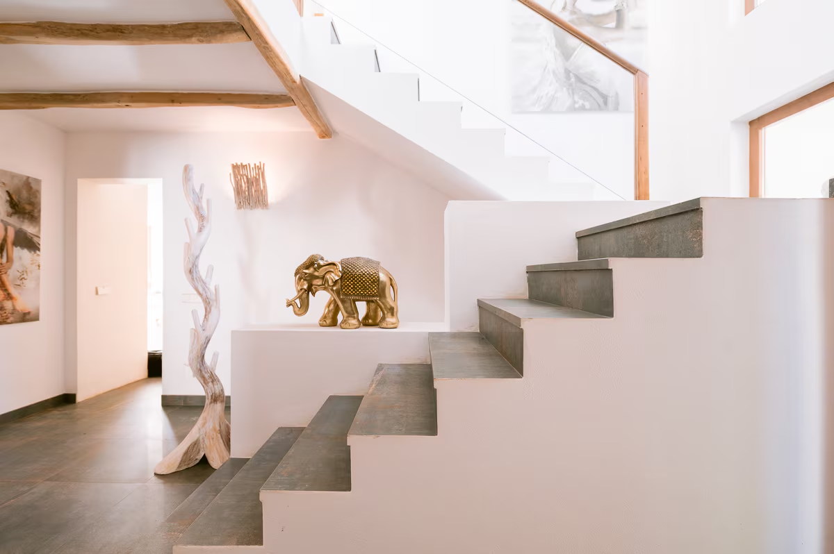 Villa staircase with natural wood accents and a gold elephant sculpture